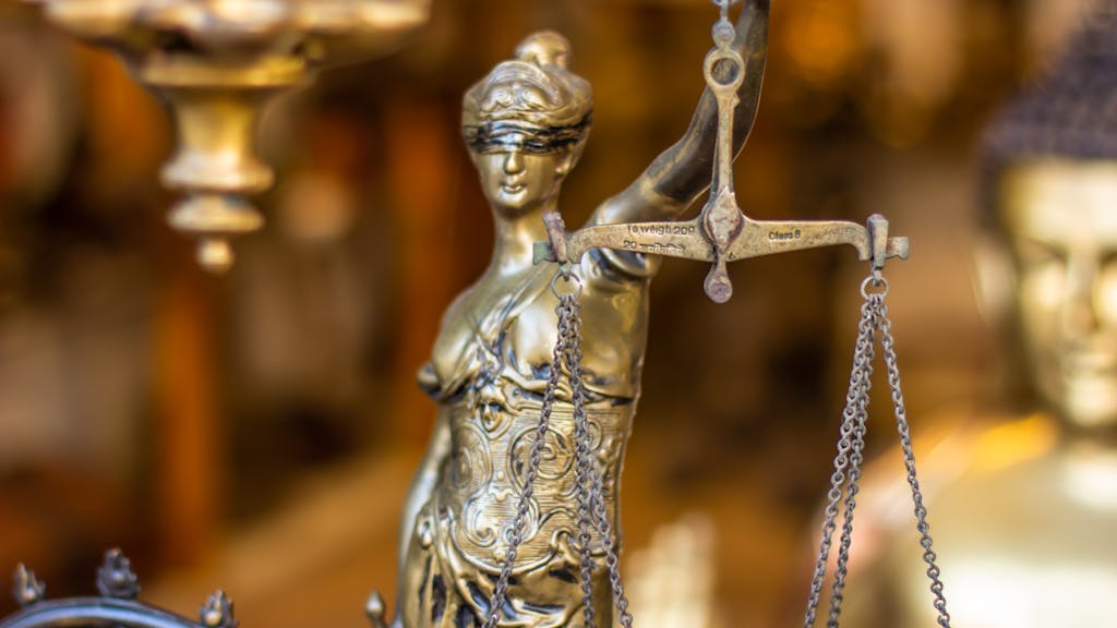 A detailed close-up of a Lady Justice statue holding scales, symbolizing law and justice.