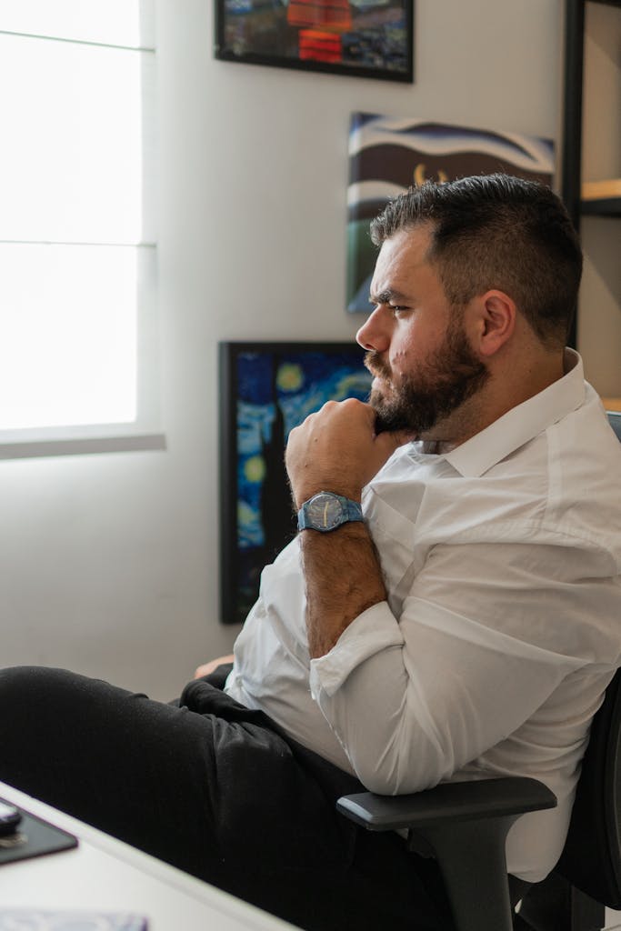 Business professional in a home office pondering over work, exhibiting focus and determination.