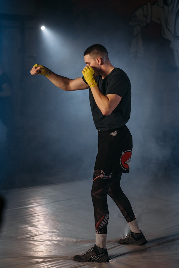 Martial artist practicing in a smoky indoor arena with vibrant lighting.